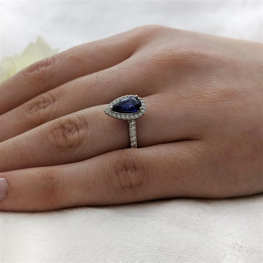 pear shape cut sapphire in a platinum cluster diamond band