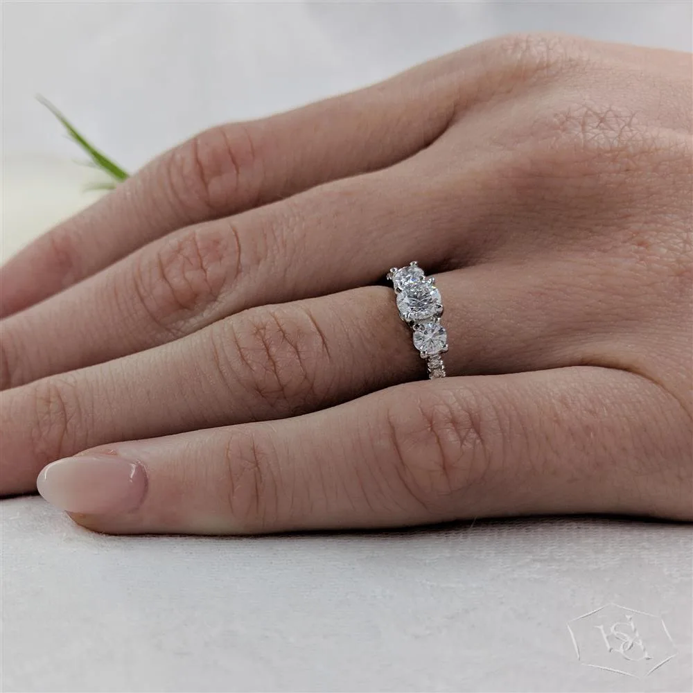 round brilliant cut diamond in a platinum three stone diamond band